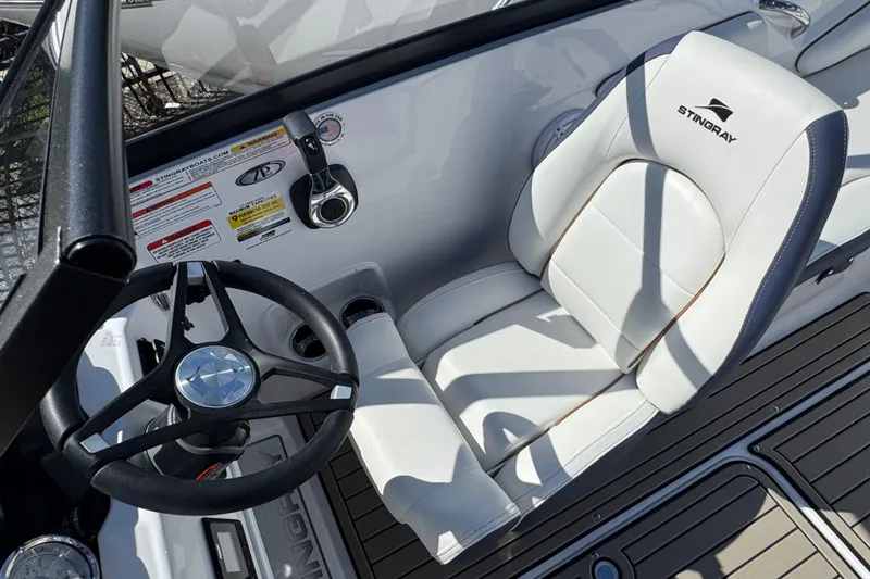 Slide: The Image of 2026 Stingray 191 DC boat cockpit with steering wheel and white seat. - 21