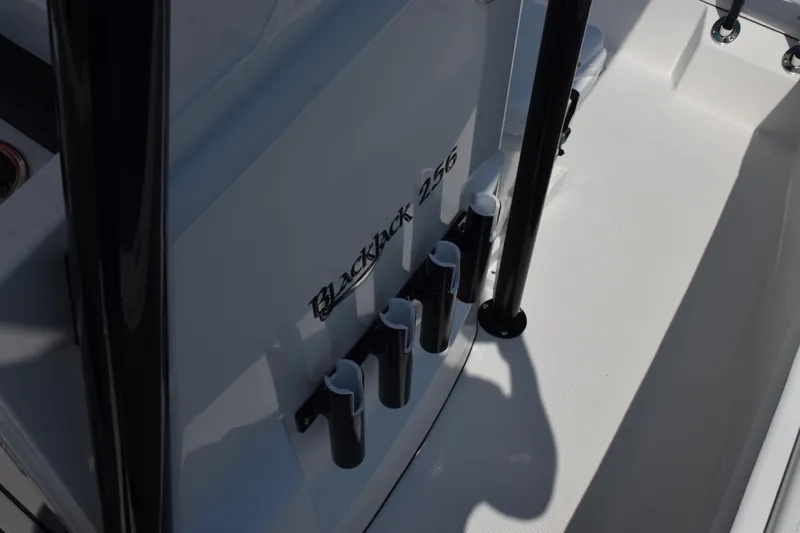 Slide: The Image of 2026 BlackJack 256 Coastal boat interior with rod holders and branding. - 14