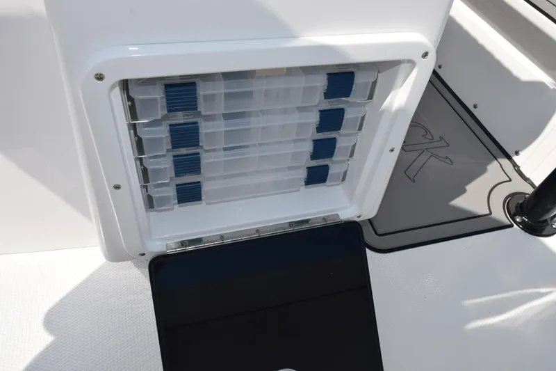 Slide: The Image of Storage compartment on 2026 BlackJack 256 Coastal boat, featuring organized tackle boxes. - 24
