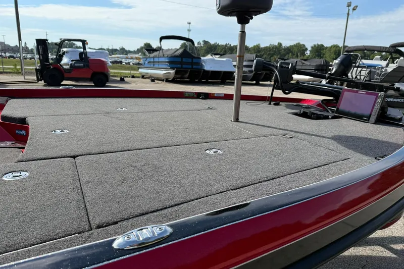 Slide: The Image of 2023 Ranger Z520R boat deck with fishing equipment, parked near other boats and vehicles. - 10