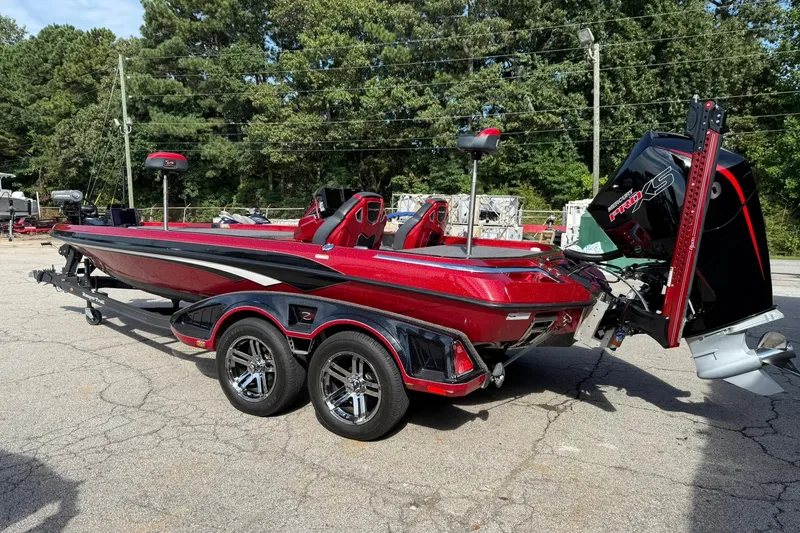 Slide: The Image of 2023 Ranger Z520R boat with dual axle trailer, parked outdoors, featuring a sleek red and black design. - 2