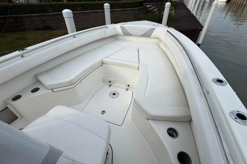 Slide: The Image of 2015 Boston Whaler 280 Outrage boat interior with white seating and cup holders. - 14
