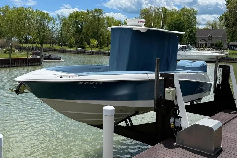 Slide: The Image of 2015 Boston Whaler 280 Outrage boat on lift, docked in a scenic marina. - 4
