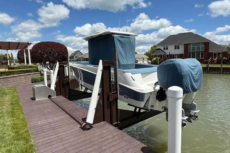 Slide: The Image of 2015 Boston Whaler 280 Outrage on a boat lift by a waterfront home. - 5