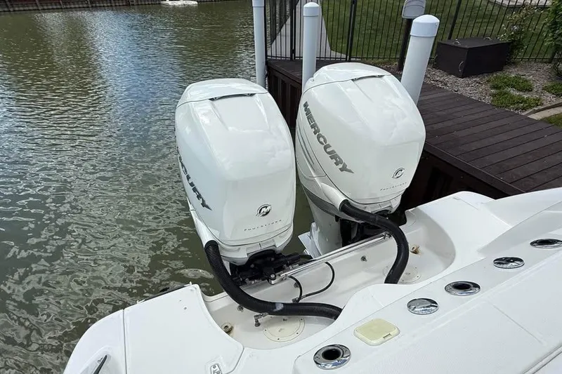 Slide: The Image of Twin Mercury outboard engines on a 2015 Boston Whaler 280 Outrage boat by the dock. - 7