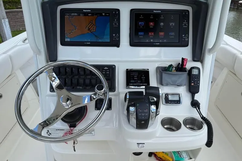 Slide: The Image of Control panel of a 2015 Boston Whaler 280 Outrage with navigation screens and steering wheel. - 9