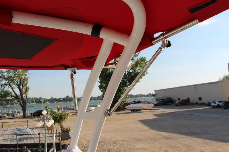 Slide: The Image of Red canopy of 2026 Cobalt R6 boat with waterfront view in background. - 52
