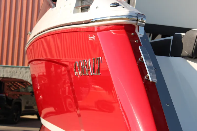 Slide: The Image of 2026 Cobalt R6 boat with a sleek red exterior, docked outdoors. - 63
