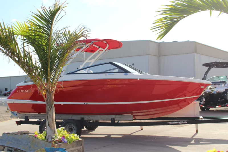 Slide: The Image of 2026 Cobalt R6 boat in vibrant red on trailer, surrounded by palm trees. - 68