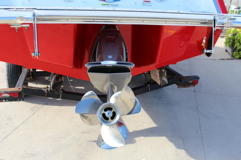 Slide: The Image of 2026 Cobalt R6 boat with shiny propeller and red hull on a trailer. - 76