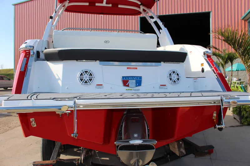 Slide: The Image of 2026 Cobalt R6 boat with red and white design, rear view at a marina. - 77
