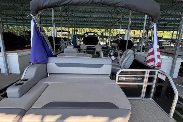 Slide: The Image of 2022 Princecraft Sportfisher 23-2S RL pontoon boat docked under a covered marina. - 14