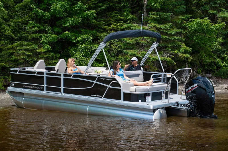Slide: The Image of Manufacturer Provided Image: 2022 Princecraft Sportfisher 23-2S RL pontoon boat on a serene lake with passengers. - 2