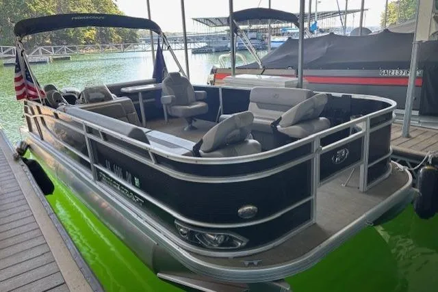 Slide: The Image of 2022 Princecraft Sportfisher 23-2S RL pontoon boat docked on a serene lake. - 21