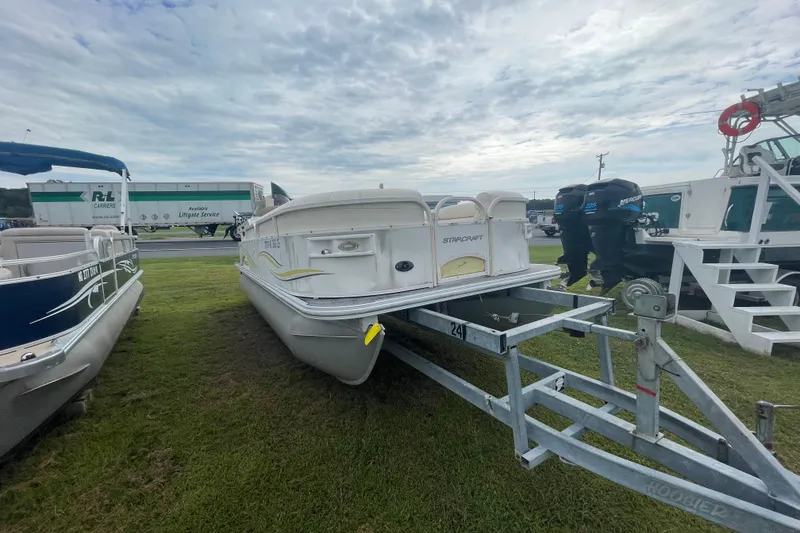 Slide: The Image of 2006 Starcraft Elite 226 pontoon boat on trailer, parked on grass under cloudy sky. - 3