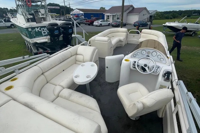 Slide: The Image of Pontoon boat interior with white seating, steering console, and table; Starcraft Elite 226, 2006 model. - 4