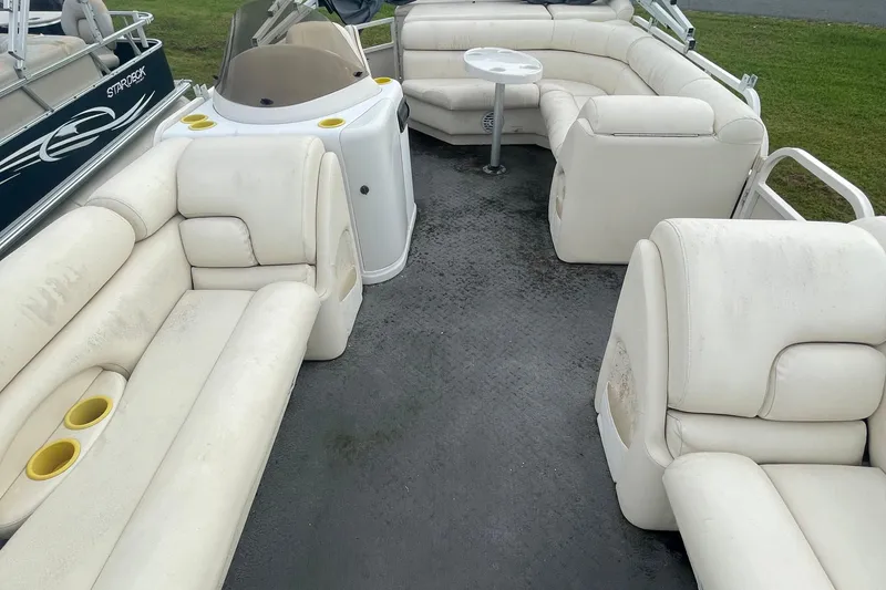 Slide: The Image of Interior of a 2006 Starcraft Elite 226 boat with white seating and a small table. - 7