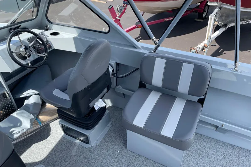 Slide: The Image of 2026 Hewescraft 180 Sportsman boat interior with steering wheel and seating. - 10