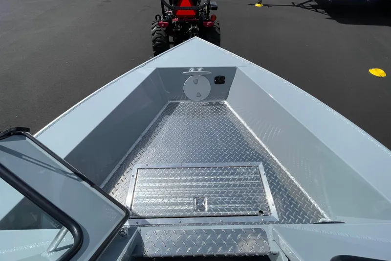 Slide: The Image of 2026 Hewescraft 180 Sportsman boat with diamond plate flooring and windshield, parked on asphalt. - 14