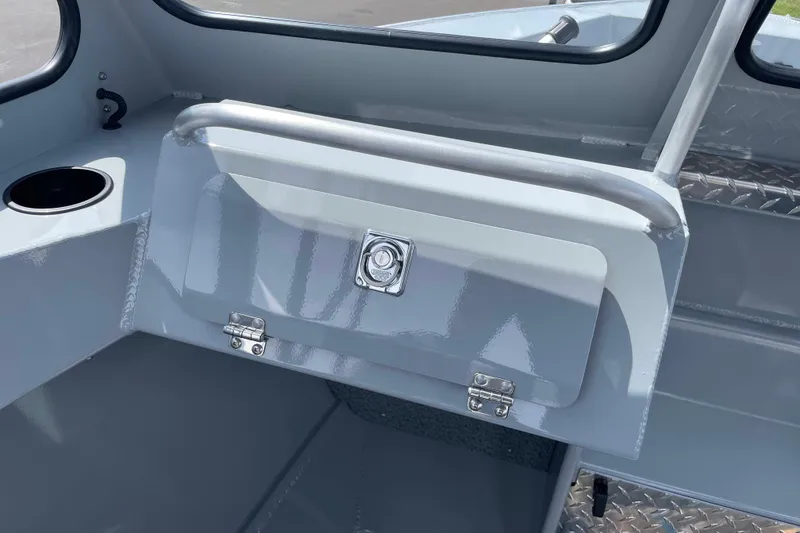 Slide: The Image of Interior of 2026 Hewescraft 180 Sportsman boat, featuring storage compartment and cup holder. - 17