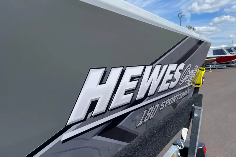 Slide: The Image of 2026 Hewescraft 180 Sportsman boat side view with bold branding. - 19