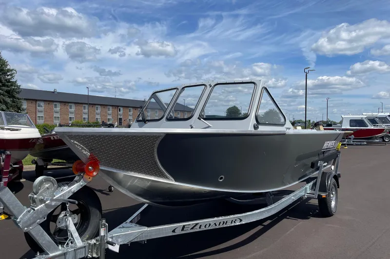 Slide: The Image of 2026 Hewescraft 180 Sportsman boat on trailer under a clear blue sky. - 3