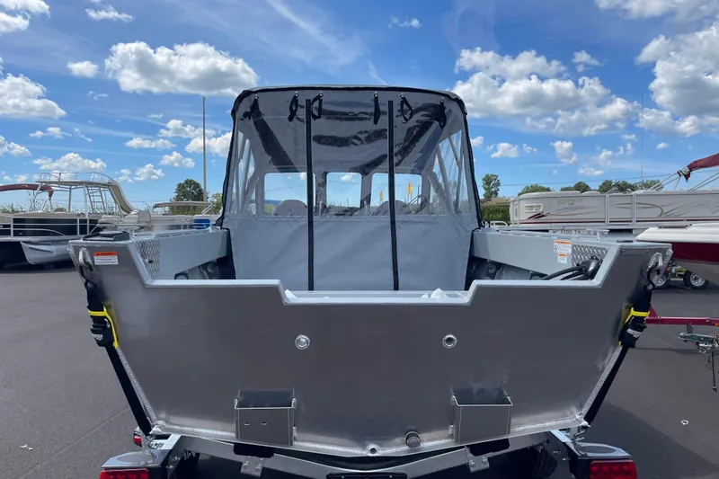 Slide: The Image of 2026 Hewescraft 180 Sportsman boat, rear view, parked under a blue sky. - 4