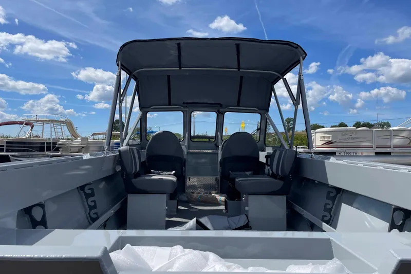 Slide: The Image of 2026 Hewescraft 180 Sportsman boat interior with canopy under blue sky. - 5