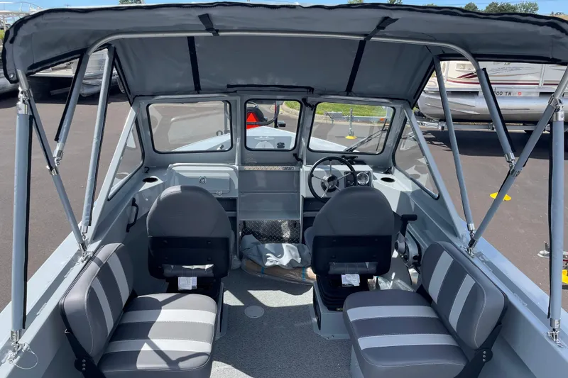 Slide: The Image of Interior view of 2026 Hewescraft 180 Sportsman boat with seating and steering console. - 8