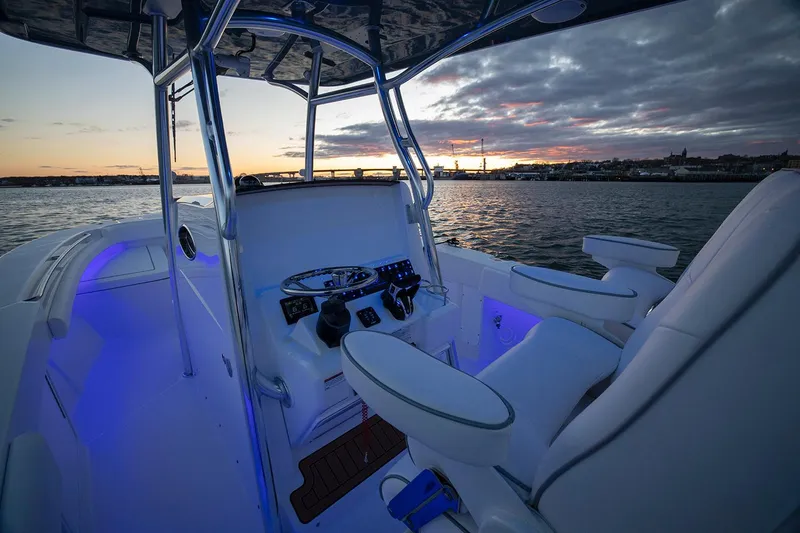 Slide: The Image of 2026 Southport 27 FE boat interior at sunset, featuring illuminated controls and seating. - 4