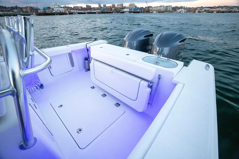 Slide: The Image of 2026 Southport 27 FE boat with dual engines, illuminated deck, and coastal backdrop. - 8