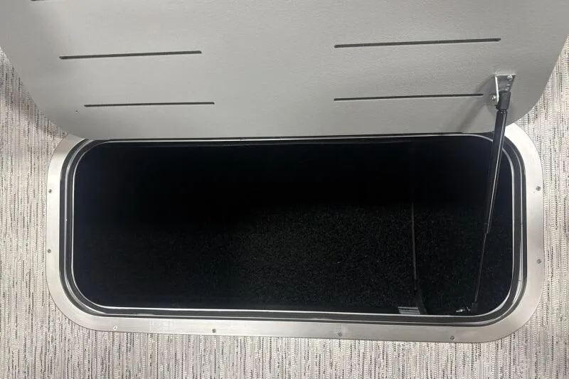 Slide: The Image of Open storage compartment on 2026 Bennington 22 SSR boat, featuring carpeted interior. - 15