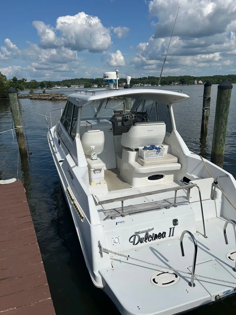 The Image of 1998 Carver Express Special Edition yacht docked at marina under cloudy sky. - 0