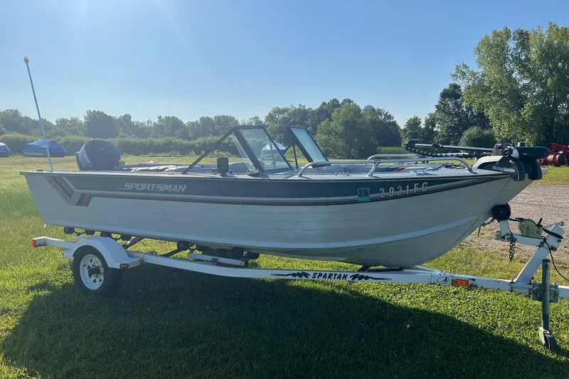 Slide: The Image of 1987 Blue Fin Sportsman boat on trailer, parked on grassy field under clear sky. - 2