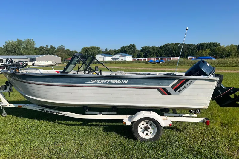 Slide: The Image of 1987 Blue Fin Sportsman boat on trailer, parked on grassy field under clear blue sky. - 3