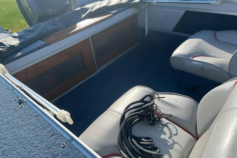 Slide: The Image of Interior of a 1987 Blue Fin Sportsman boat with gray seating and coiled rope. - 4