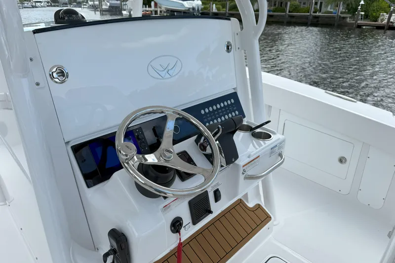 Slide: The Image of 2026 Southport 30 FE boat helm with steering wheel and control panel. - 12