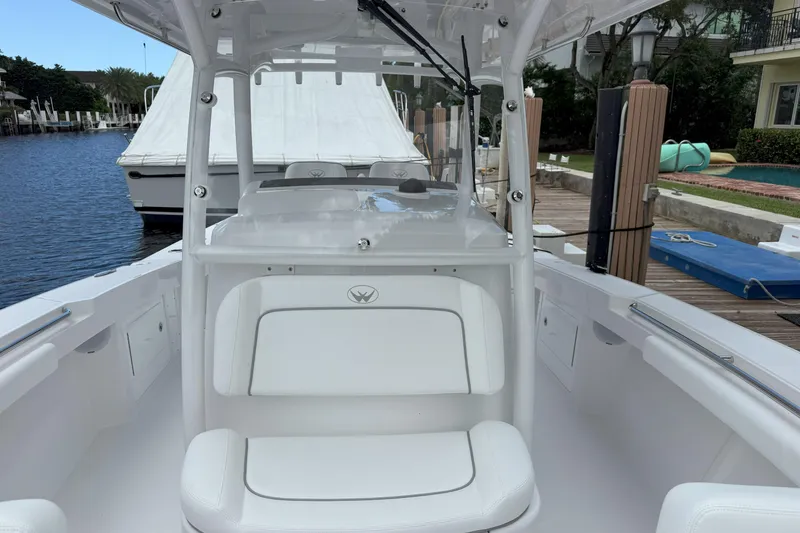 Slide: The Image of 2026 Southport 30 FE boat interior, featuring white seating and sleek design at a dock. - 14