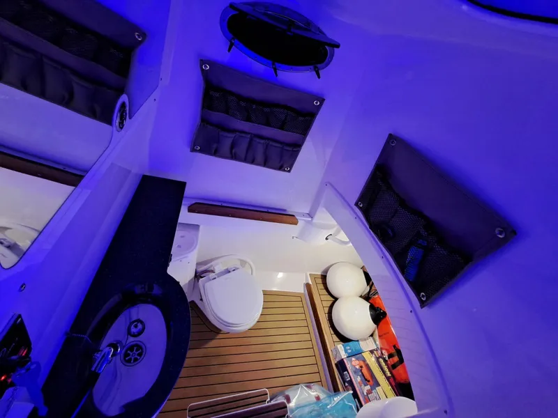 Slide: The Image of 2024 Southport 30 FE boat interior with blue lighting, toilet, and storage compartments. - 23