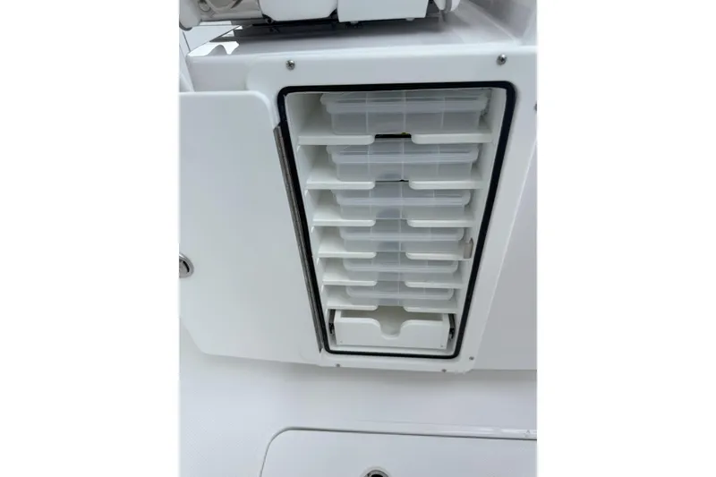 Slide: The Image of Storage compartment on 2026 Southport 30 FE boat, featuring organized plastic trays. - 24