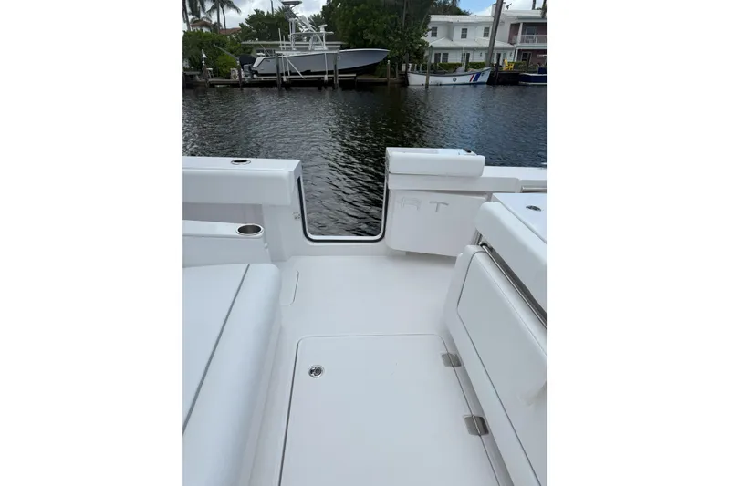 Slide: The Image of 2026 Southport 30 FE boat interior with white seating, docked by waterfront homes. - 5