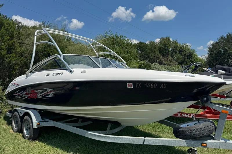 Slide: The Image of 2006 Yamaha Boats AR230 HO on trailer, parked outdoors, under a clear blue sky. - 1