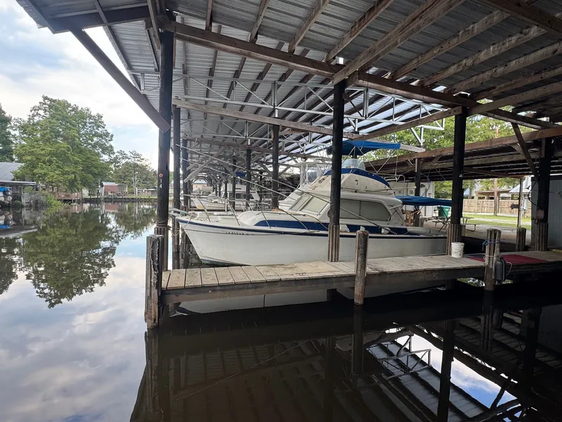 The Image of 1963 Hatteras Sport Fisherman boat docked in a covered marina. - 0
