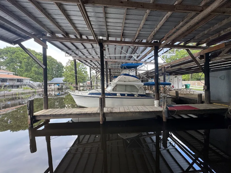 Slide: The Image of 1963 Hatteras Sport Fisherman docked under a covered marina. - 1