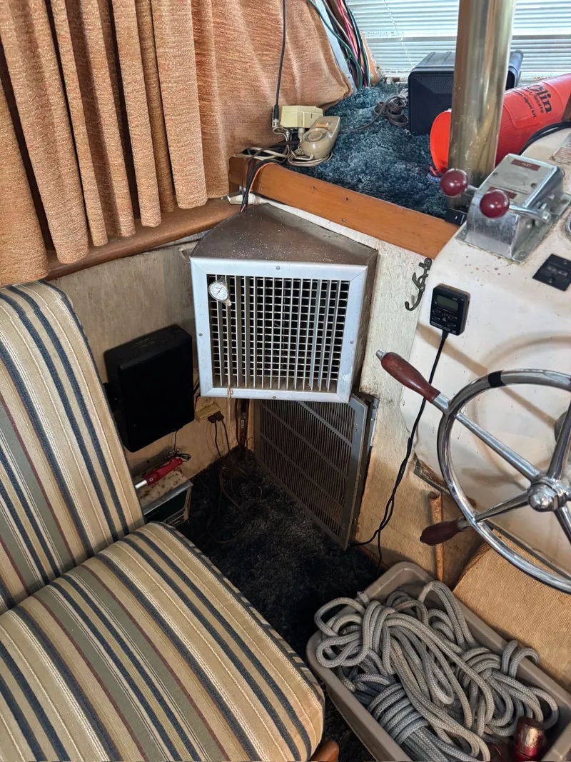 Slide: The Image of 1963 Hatteras Sport Fisherman interior with striped chair, steering wheel, and nautical equipment. - 11