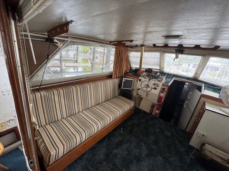 Slide: The Image of Interior of a 1963 Hatteras Sport Fisherman boat with striped seating and navigation area. - 13