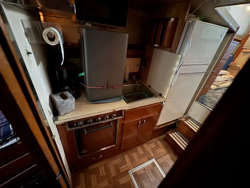Slide: The Image of 1963 Hatteras Sport Fisherman kitchen with stove, sink, and refrigerator. - 18