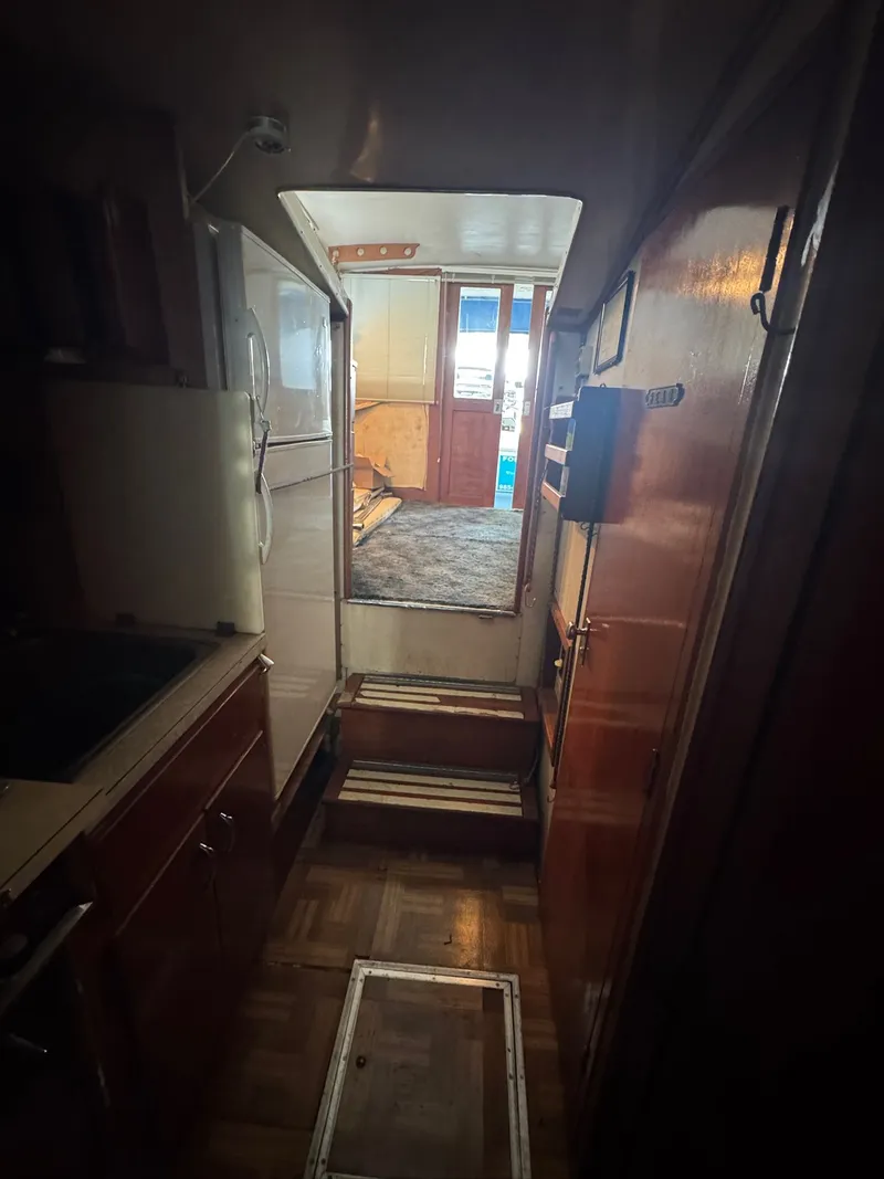 Slide: The Image of Interior view of 1963 Hatteras Sport Fisherman boat, featuring wooden cabinetry and compact layout. - 19