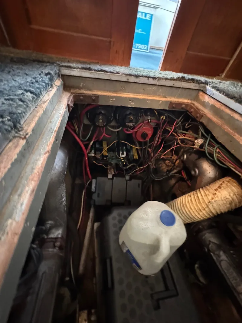 Slide: The Image of Engine compartment of a 1963 Hatteras Sport Fisherman boat with visible wiring and components. - 23