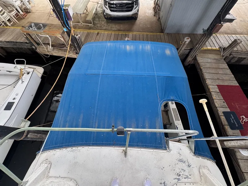 Slide: The Image of 1963 Hatteras Sport Fisherman with blue canopy docked at marina. - 6